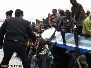 Libyan police officers help rescued migrants off an overcrowded boat that arrived this week in Tripoli.
