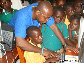 Seth Owusu shows children in his native Ghana how to use a computer during his visit in June.