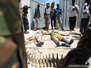 Al Shabaab fighters display two bodies of Somali police officers during a battle August 12 in Mogadishu.