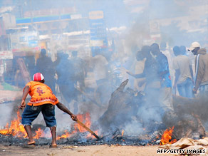 A man tries to put out a fire on Friday in Kasubi, Uganda, a suburb of Kampala.