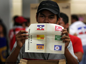 A polling station president in San Salvador shows marked ballots Sunday at the close of voting.