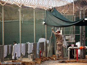 A guard talks to a Guantanamo detainee, inside the open yard at Camp 4 detention center, this week.