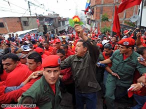 Venezuela President Hugo Chavez waves to people in a poor neighborhood in Caracas on Friday.