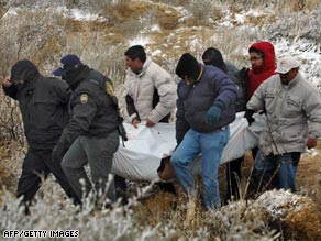 Mexican police carry a body after a clash with gangs that left 21 dead in the state of Chihuahua on February 10.