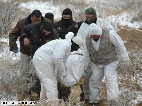 Mexican police carry a body after a clash with gangs that left 21 dead in the state of Chihuahua on February 10.