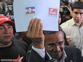 FMLN's Mauricio Funes shows his ballot before voting Sunday in Antiguo Cuscatlan, El Salvador.