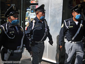 Police officers take precautions against the swine flu outbreak as they patrol streets Wednesday in Mexico City.