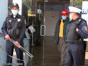 Armed guards stand outside the Mexico City Respiratory Hospital to control the flow of people.