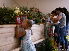 A girl stands at the coffin of Mormon church leader Benjamin LeBaron in Chihuahua State.