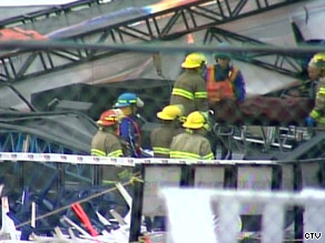 Rescue workers remove a victim from the debris caused by Saturday's stage collapse at the Big Valley Jamboree.