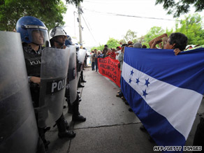Riot police stand in front of marchers supporting ousted Honduran President Manuel Zelaya on Tuesday.