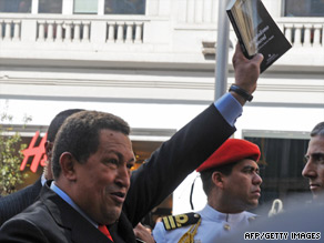 Venezuelan President Hugo Chavez waves a book Friday during a visit to Madrid, Spain.