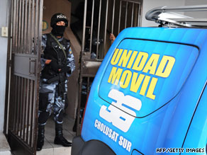 A Honduran policeman stands guard Monday at the closed-down building of the Canal 36 TV station.