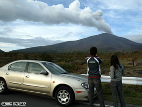 Motorists stop to watch Mount Asama erupt on September 17, 2004.