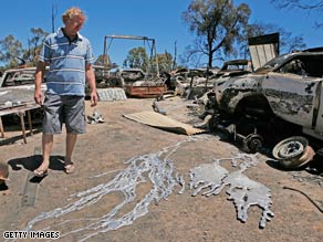 Craig Kidd looks at the melted wheels of his vehicles after a fire swept his property on February 9 in Bendigo.