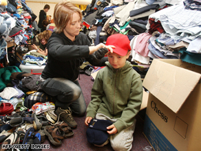 A woman dresses a  boy in donated clothes in Whittlesea, north of Melbourne.