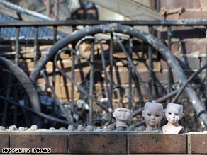 Porcelain dolls sit in front of a burnt house in the township of Phesant Creek, 100km north of Melbourne.