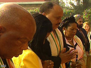 Martin Luther King III, center, reflects at the site of Mahatma Gandhi's memorial.