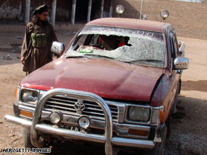 A man stands beside a damaged vehicle after a Pakistani attack on Taliban militants on the Afghan border.