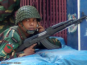Bangladeshi soldiers take position armed with automatic weapons in Dhaka on Wednesday.