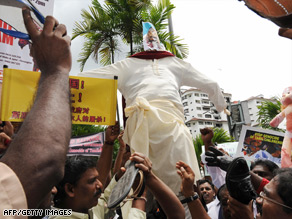 Ethnic Tamils beat an effigy of Sri Lanka's Prime Minister with shoes in front of the U.N. office in Kuala Lumpur.