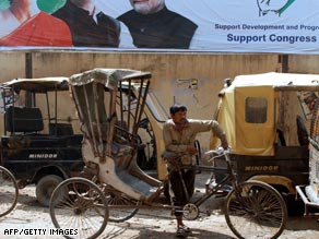 A rickshaw driver waits for customers under a Congress party poster in Dimapur, India, on Thursday.