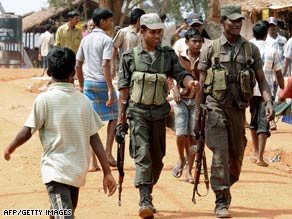 Sri Lankan soldiers patrol a shelter for war-displaced Tamils in Vavuniya in late February.