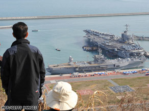 South Koreans look at the USS John C. Stennis and the USS Blue Ridge in Busan Wednesday.