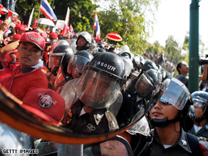 Supporters of former PM Thaksin Shinawatra confront riot policemen outside Government House.