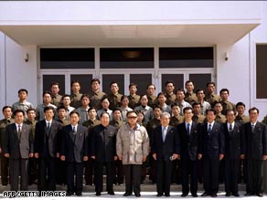 Picture released by North Korean state news agency shows Kim Jong Il, center, with staff from the rocket team.