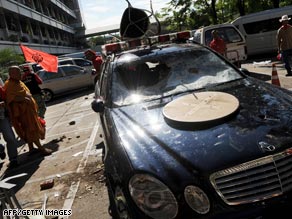 Protesters surround a damaged car inside the interior ministry compound in Bangkok.