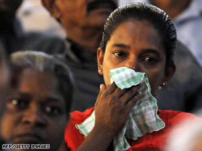 A relative of a deceased serviceman wipes away tears Monday at ceremonies at a Colombo suburb.