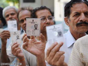 Indians voters hold up their voter ID cards at a polling station in northern India.