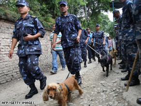 Police with sniffer dogs investigate the scene of a blast at a church in Kathmandu.