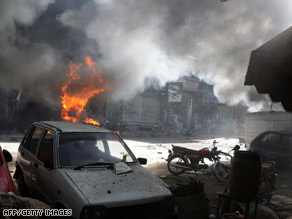 Pakistanis look Thursday at the rubble of a police building in Lahore hit by a suicide bomb on Wednesday.