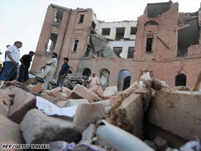Pakistanis look Thursday at the rubble of a police building in Lahore hit by a suicide bomb on Wednesday.