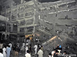 Two women cover their mouths, as they leave the bombed hotel.