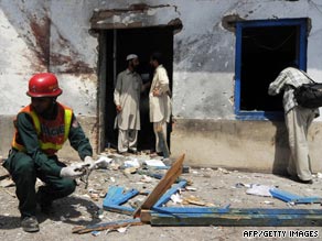 A Pakistani rescue worker works outside a damaged room of Jamia Naimia religious school.