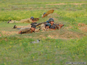 Indian paramilitary soldiers take up positions, as they proceed towards the villages of Lalgarh on Thursday.