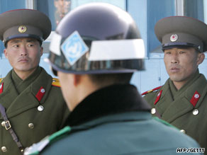 N. Korean army soldiers, back, look at a S. Korean soldier, center, in the demilitarized zone in June.