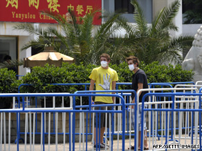 Two students outside the Yan Xiang Hotel where a group of British children and teachers have been quarantined.