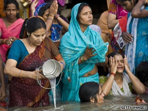 Hindu women pray as they bathe in the River Ganges after the total solar eclipse in India.
