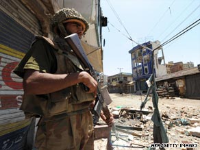 A Pakistani soldier patrols a ruined street in Mingora.