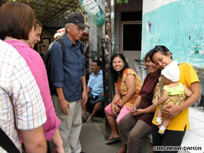 Ronny Poluan (in cap), who runs "Jakarta Hidden Tours," takes a group through a Jakarta slum.