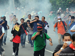 Protesters in Kuala Lumpur flee after police open fire with tear gas.