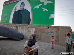 Afghans stand in front of a poster of President Hamid Karzai last week in Kabul, Afghanistan.
