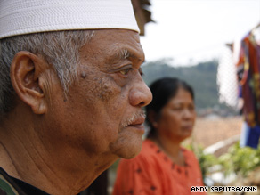 Subandi looks at the shell of his home. The second story fell through to the first floor.