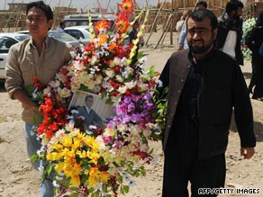 Journalists carry flowers to the grave of Afghan journalist Sultan Munadi in Kabul on Thursday.