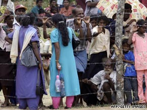 Tamil civilians, pictured in May, stand behind a barbed-wire fence at a refugee camp near the northern Sri Lankan town of Vavuniya.