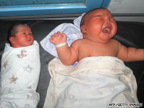 The giant baby lies next to a more typically-sized newborn.